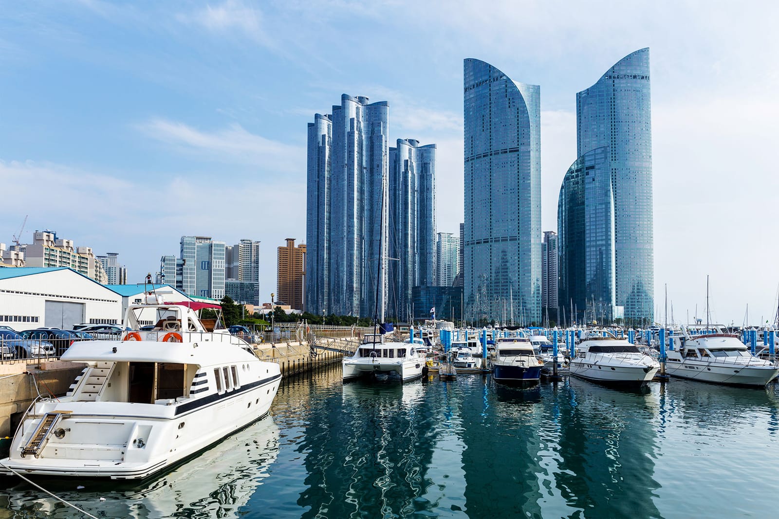 Puerto deportivo de Busan con yates y rascacielos de vidrio