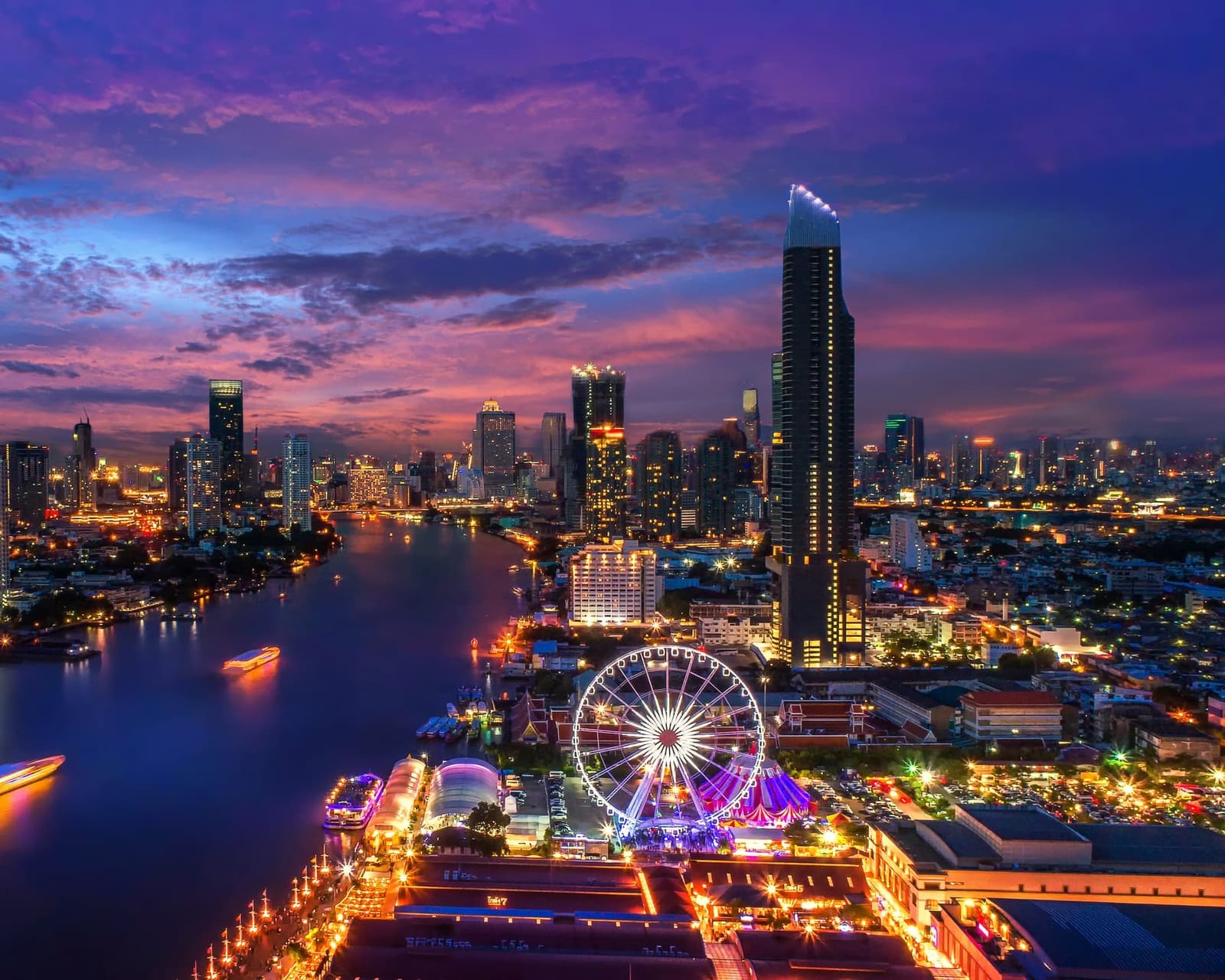Río Chao Phraya y rascacielos de Bangkok al anochecer